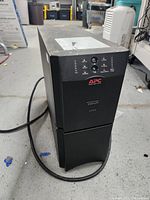 Front view of APC Smart-UPS 2200 UPS showing APC logo, indicator lights and buttons.