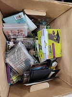 Box filled with assorted craft items including markers, glue gun box, and craft supplies.