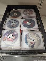 Top-down view of DVDs in plastic sleeves inside the crate showing some visible titles
