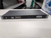 Front panel of Grandstream communication device showing Ethernet ports, USB, LCD, and control buttons.