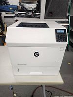 Front view of HP LaserJet Enterprise M604 printer showing the control panel and display.