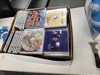 Top view showing tightly packed CDs in jewel cases inside a white bankers box.