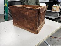 Side angle view showing the rustic wood and visible wear on the crate.
