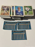 Stacks of 1990 Bowman baseball cards showing the front card images of players in baseball uniforms with the backs displaying player stats in blue background.