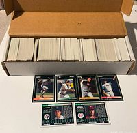 Long box filled with multiple bundles of 1992 Pinnacle baseball cards. Loose cards visible laid out in front showing front images of players in team uniforms mid-action.