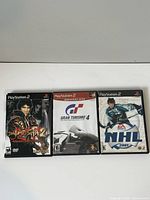 Photo showing the front covers of three PlayStation 2 game cases: Onimusha 2, Gran Turismo 4 Greatest Hits, and NHL 2001.