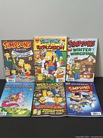 Lot of 6 Simpsons comic books arranged in two rows, showing cover art clearly.