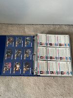 Blue binder open showing clear plastic sleeves with Star Trek trading cards featuring colorful character images on one side.