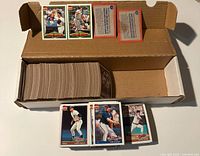 Top-down view of the open box filled with the 1991 Topps baseball cards, cards laid out in front and inside the box.