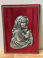 Front view of vintage religious plaque showing detailed pewter Madonna and Child on red velvet background with gold trim.