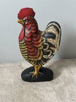 Front view of the vintage hand-carved wooden rooster figurine showing detailed paintwork and upright stance on black base.