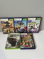 Front view of five Xbox 360 Kinect game cases arranged upright showing cover art