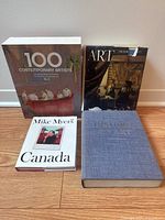 Four art books on floor, including 100 Contemporary Artists set, Art by Frederick Hartt, Mike Myers Canada, and The Story of Art.