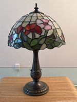 Full front view of lamp showing stained glass shade and metal base