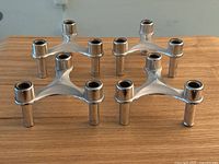 Four vintage Seca chrome space age candlesticks displayed on wood surface.