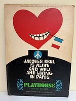 Full view of the vintage theatre poster with red heart, teeth, peace symbol, flags, and text.