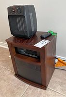 Airchoice heater on top of Lancaster heater with remote control visible