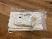 Packaged set of folded vintage linens including hand towels and tablecloths in plastic wrap with lot tag.