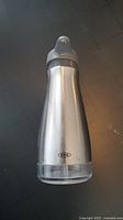 Front view of OXO stainless steel soap dispenser showing silver finish and pump top.