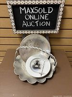 Overall photo showing the six side plates stacked on the pressed aluminum tray with twisted handle, and the silver plate bowl behind the tray.