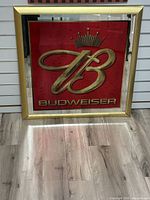 Full view of square Budweiser bar mirror with gold frame and red background.