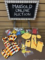 Overview of the entire lot showing crocheted doll clothes, plastic doll boots, shoes, brushes, miniature hangers, and other small plastic accessories arranged on a flat surface.