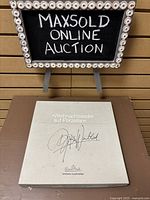 Photo of the grey Rosenthal box with the printed title 'Weihnachtslieder auf Porzellan' and artist signature on the top surface.