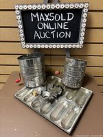Photo showing two metal flour sifters, a vintage metal baking pan, and a tree-shaped cookie cutter.