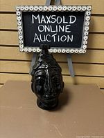 Front view of the black glass Xtabetum bottle with unique face design and glass/cork stopper.