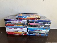 Two stacks of DVDs showing titles including animated and family films like 'Meet the Robinsons', 'Spider-Man', 'High School Musical 3', 'The Incredibles' and more.