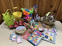 Large grouping of Easter essentials on table, showing baskets, candy bags, plastic eggs, egg decorating kit, and home decor items