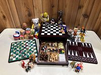 Lot of children's toys and collectible figures arranged on a table showing wooden game boards, character figurines, blocks, and game pieces.