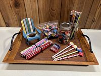 Photo of wooden tray holding mini Muskoka chair, bundles of new pencils, plastic bag and jar of novelty erasers, and two pencil sharpeners