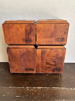 Front view of four wooden canisters stacked in two rows. Markings for Coffee, Tea, Flour, Sugar visible on fronts.
