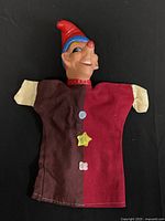 Full view of puppet showing clown head and fabric body with staining