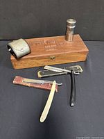 Full lot overview showing 2 straight razors, shaving stick container, sharpener, and wooden box