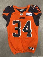 Front view of the BC Lions orange football jersey numbered 34 with CFL and Telus patches