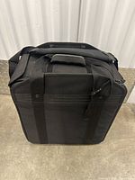 Black padded carrying case for lighting equipment with handle and shoulder strap