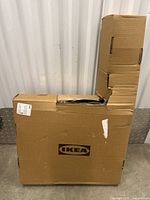 Closed cardboard box labeled Ikea with some damage and wear.
