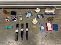 Overview of entire lot showing multiple watches, jewelry boxes, perfume bottle, and costume jewelry items