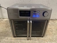 Front view of stainless steel Kalorik appliance with digital control panel and dual doors.