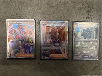 Three Pokemon trading cards from the Prismatic Evolutions series shown on grey surface: Friends in Paldea, Tyme Trainer, and Bronzor, all in protective sleeves with holographic finish.