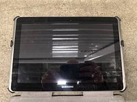 Front view of Samsung tablet with black screen and Samsung logo visible at the bottom center.