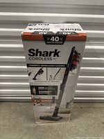 Photo of boxed Shark cordless pet vacuum cleaner showing product image and marketing information.