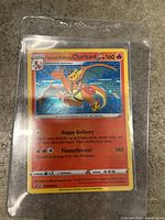 Front side of Special Delivery Charizard card in plastic sleeve on granite surface.