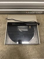 Top view of the Technics SL-Q5 turntable with dust cover and power cord on the ground.