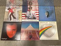 Photo of six vinyl record albums on a metal surface.