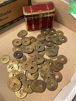 Overview of tin and pile of coins in box