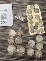 Overview of entire lot on table: two silver dollars, mixed fifty-cent pieces, small dimes and assorted quarters and dimes.