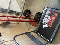 Photo showing red hand dolly with metal frame and solid rubber wheels.